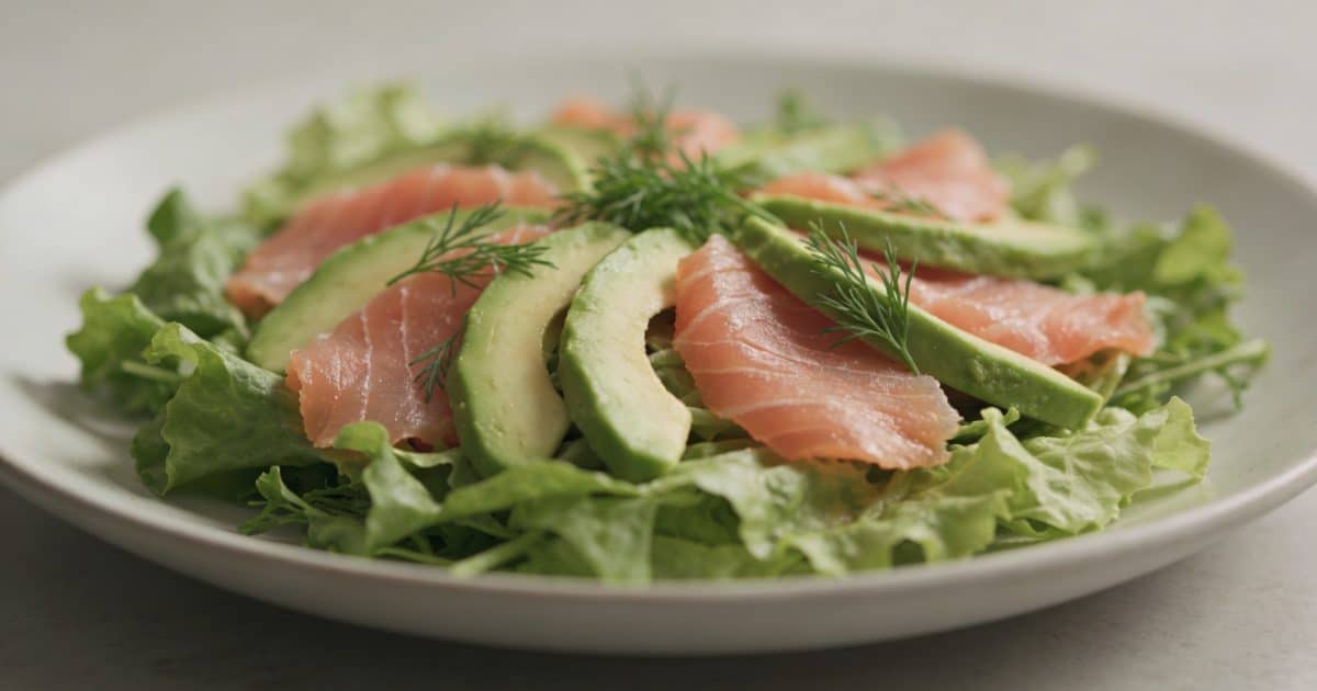 Assiette de salade verte avec tranches de saumon fumé et lamelles davocat