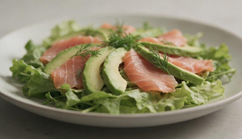 Assiette de salade verte avec tranches de saumon fumé et lamelles davocat
