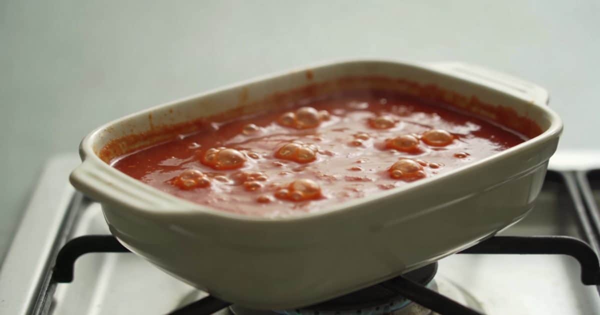 Casserole de sauce tomate frémissante sur cuisiniere