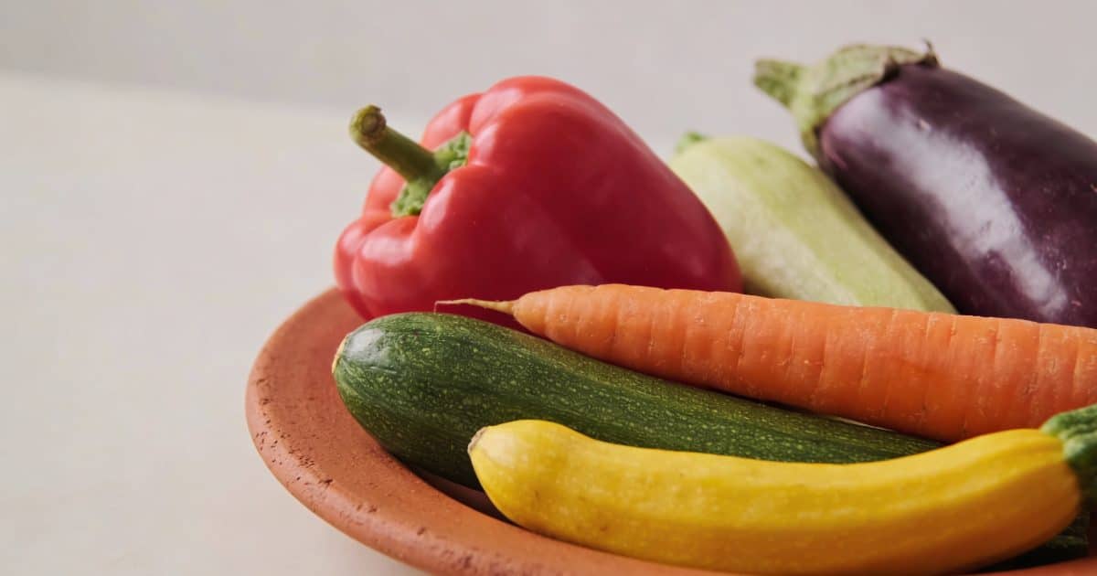 Plat en terre cuite rempli de legumes colores