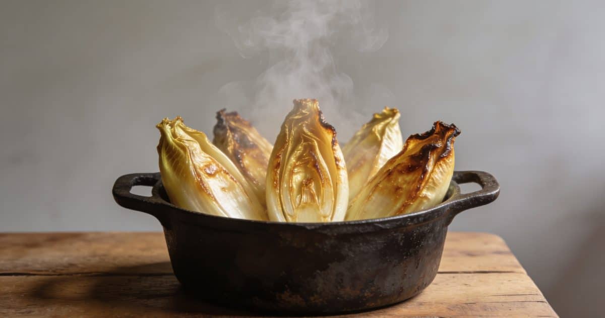 Poele en fonte avec endives dorees et fumantes